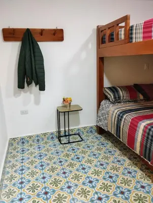 a bedroom with a bed and a table on a floor at Jericó un pueblo de ensueño in Jericó