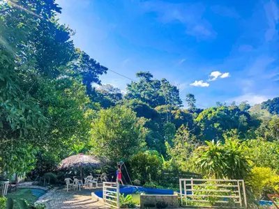 a garden with a table and chairs and trees at El Refugio Eco Hostal Caracolí in Cascarón