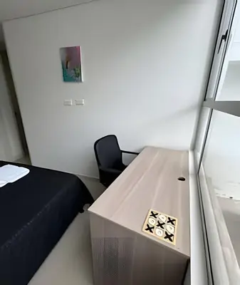 a small room with a bed and a wooden table at Moderno y cómodo cerca al cable in Manizales