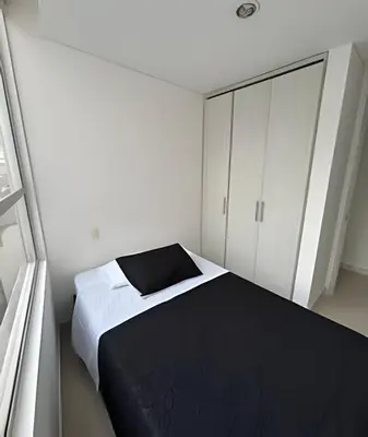 a bedroom with a black bed and white cabinets at Moderno y cómodo cerca al cable in Manizales