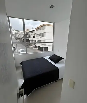 a bedroom with a bed and a large window at Moderno y cómodo cerca al cable in Manizales