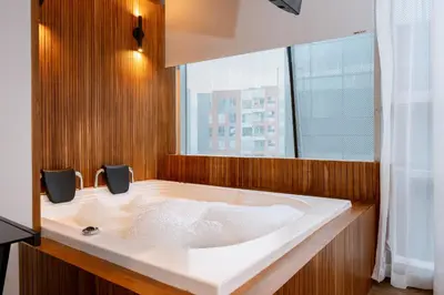 a bathroom with a bath tub with a large window at Bio 26 Apartments in Medellín