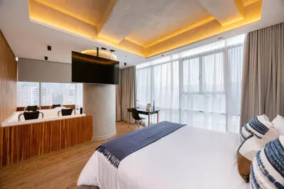 a bedroom with a bed and a desk in a room at Bio 26 Apartments in Medellín