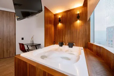 a large bath tub in a room with a window at Bio 26 Apartments in Medellín