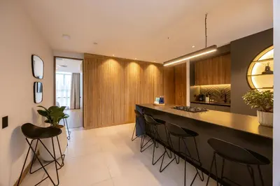 a kitchen with a long bar with stools at Bio 26 Apartments in Medellín