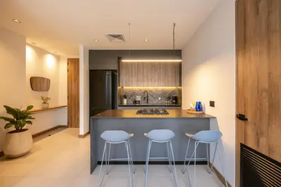 a kitchen with three stools at a kitchen counter at Bio 26 Apartments in Medellín