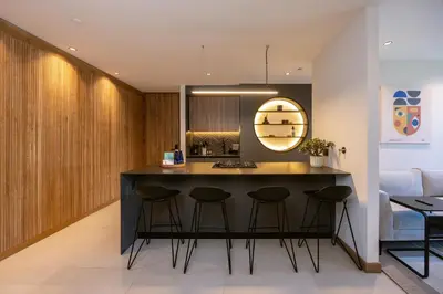 a kitchen with a black island with stools at Bio 26 Apartments in Medellín