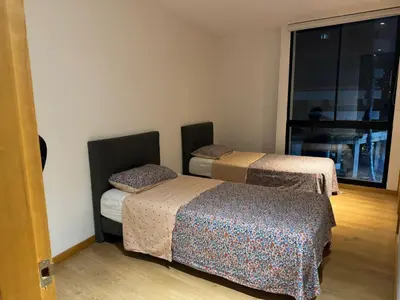 two beds in a room with a window at Apartamento Santa Coloma - WAKE FRONT in Medellín