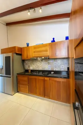a kitchen with wooden cabinets and a stainless steel refrigerator at Soluna Apartamento Jericó Parque in Jericó