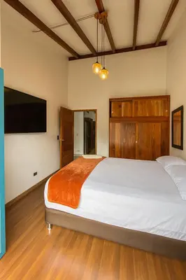 a bedroom with a large bed and a flat screen tv at Soluna Apartamento Jericó Parque in Jericó