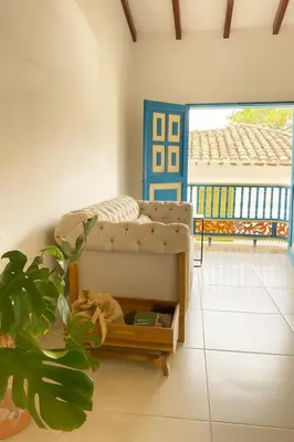 a bed in a room with a plant and a door at Soluna Apartamento Jericó Parque in Jericó