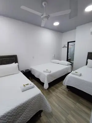 a room with two beds and a ceiling fan at Hotel Internacional Boutique Milan in Puerto Boyacá