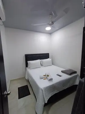 a bedroom with a white bed with a ceiling at Hotel Internacional Boutique Milan in Puerto Boyacá