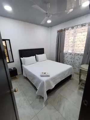 a bedroom with a bed with white sheets and a ceiling at Hotel Internacional Boutique Milan in Puerto Boyacá