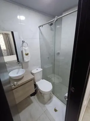 a bathroom with a toilet and a glass shower at Hotel Internacional Boutique Milan in Puerto Boyacá