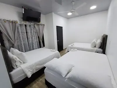 a room with two beds and a tv on the wall at Hotel Internacional Boutique Milan in Puerto Boyacá
