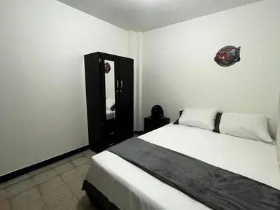 a bedroom with a bed and a mirror on the wall at Hogar El Descanso Itagui in Itagüí