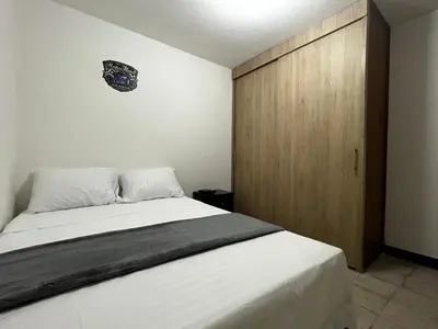 a bedroom with a bed and a wooden cabinet at Hogar El Descanso Itagui in Itagüí