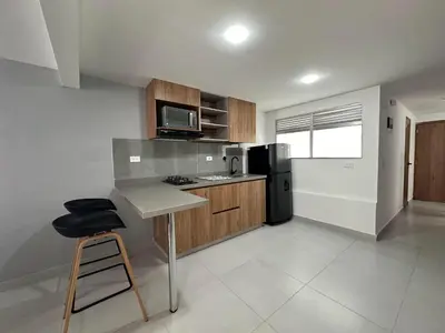 a kitchen with a counter and a stool in it at Modernos apartamentos cerca al Poblado in Medellín