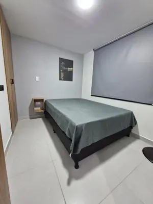 a bedroom with a bed and a large screen at Modernos apartamentos cerca al Poblado in Medellín