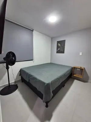 a bedroom with a bed in a room with a fan at Modernos apartamentos cerca al Poblado in Medellín
