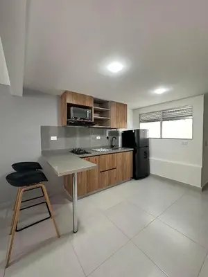 a kitchen with a table and a black refrigerator at Modernos apartamentos cerca al Poblado in Medellín