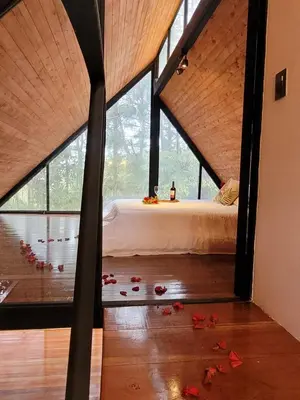 a bedroom with a bed and some petals on the floor at Cabaña Onix - La Pascana Ecolodge in Mazo