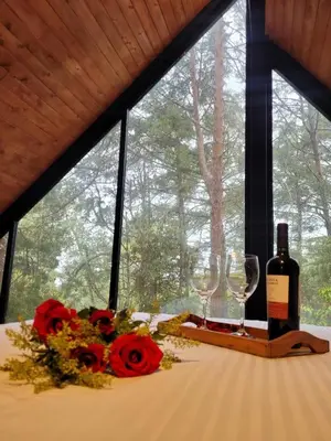a table with a bottle of wine and two glasses at Cabaña Onix - La Pascana Ecolodge in Mazo