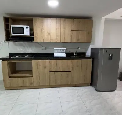 a kitchen with wooden cabinets and a microwave at Alojamiento en Sonsón in Sonsón