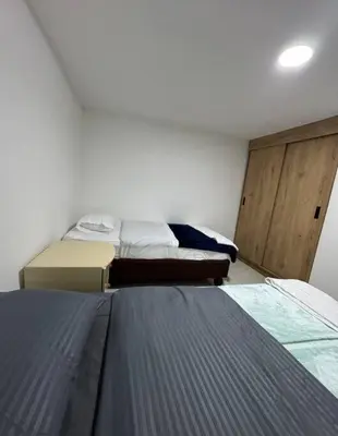 a bedroom with two beds and a wooden door at Alojamiento en Sonsón in Sonsón