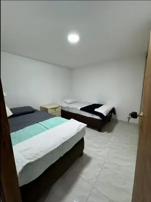 a bedroom with two beds and a door open at Alojamiento en Sonsón in Sonsón