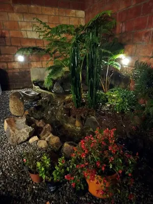 a garden with plants and flowers in front of a brick wall at Patio Chic in Jericó