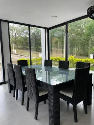 a glass table and chairs in a room with windows at Casa Lili in Sopetran