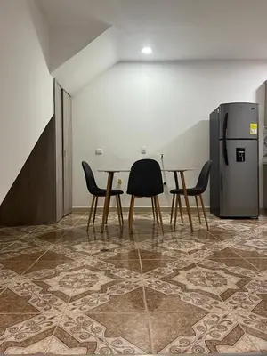 a dining room with a table and chairs and a refrigerator at Agua Clara Apartamento in San Rafael