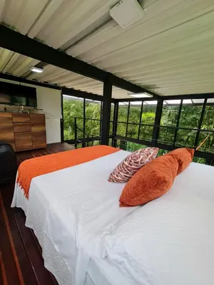 two white beds in a room with windows at Los Bambúes in El Peñol