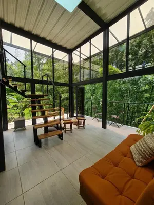 a living room with a couch and glass walls at Los Bambúes in El Peñol