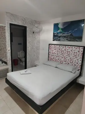 a bedroom with a large bed with a white mattress at Hotel Medellin Park in Medellín