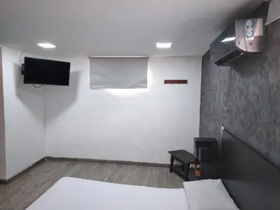 a room with a bed and a tv on the wall at Hotel Medellin Park in Medellín
