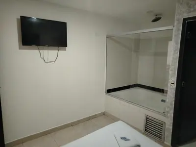 a bathroom with a tv and a basketball hoop on the wall at Hotel Medellin Park in Medellín