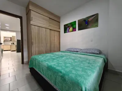 a bedroom with a bed with a green comforter at Apartamento nuevo en primer piso in Jardin