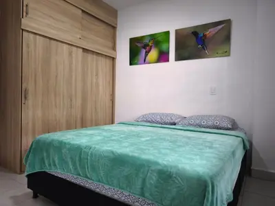 a bedroom with a bed and a wooden cabinet at Apartamento nuevo en primer piso in Jardin