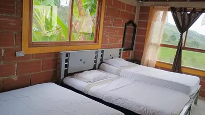 three beds sitting in a room with a window at Cabaña Campestre San Gabriel in Angostura