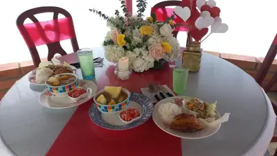 a table with plates of food and flowers on it at Cabaña Campestre San Gabriel in Angostura