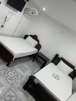 a small room with two beds and a table at Habitación doble, con desayuno - La Casona Hotel in La Pintada