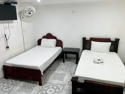 a room with two beds and a fan at Habitación doble, con desayuno - La Casona Hotel in La Pintada