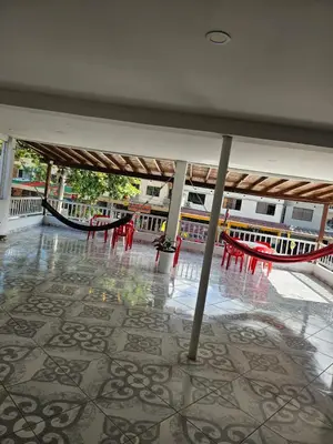 a room with tables and hammocks in a building at Habitación doble, con desayuno - La Casona Hotel in La Pintada