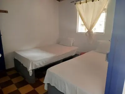 two beds in a small room with a window at Habitación doble, con desayuno - La Casona Hotel in La Pintada