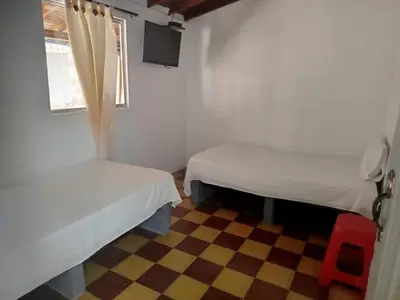 a small room with two beds and a window at Habitación doble, con desayuno - La Casona Hotel in La Pintada
