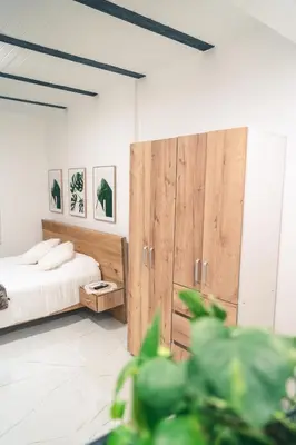 a bedroom with a bed and a large wooden cabinet at Apto 203 - Casa bendita in Medellín