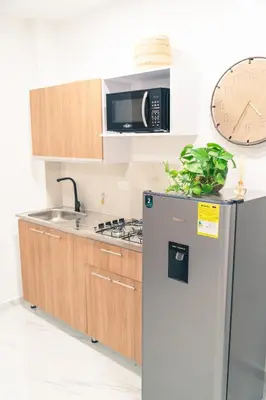 a kitchen with a stainless steel refrigerator and a clock at Apto 203 - Casa bendita in Medellín